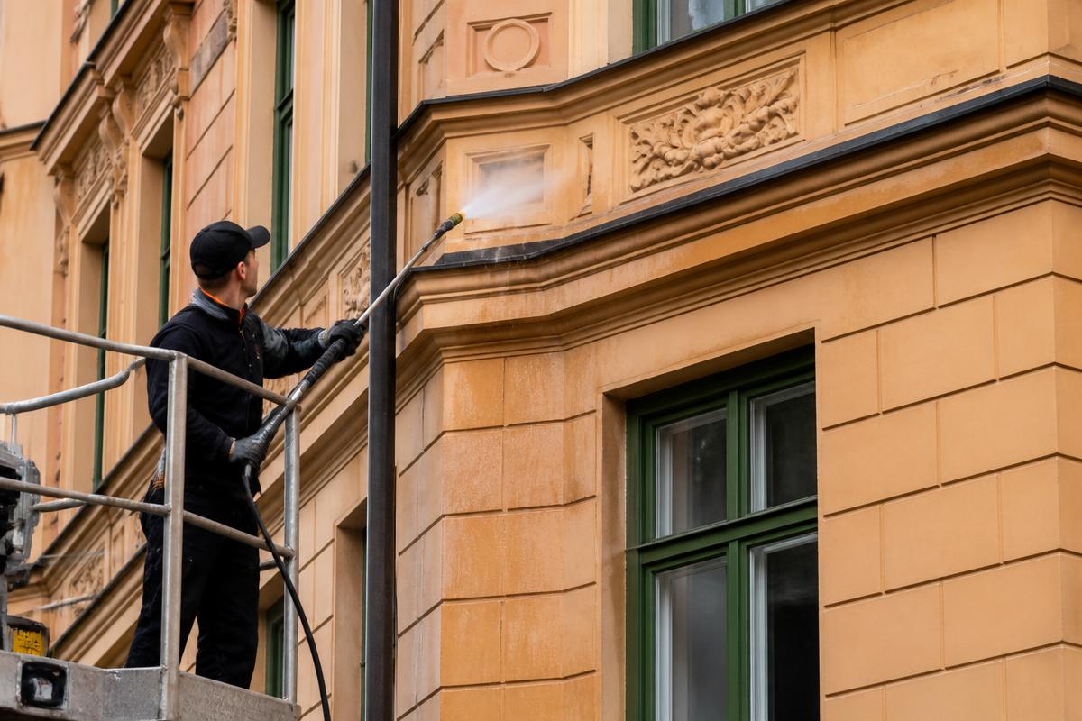 Hantverkare fasadtvättar ett klassiskt stockholmshus